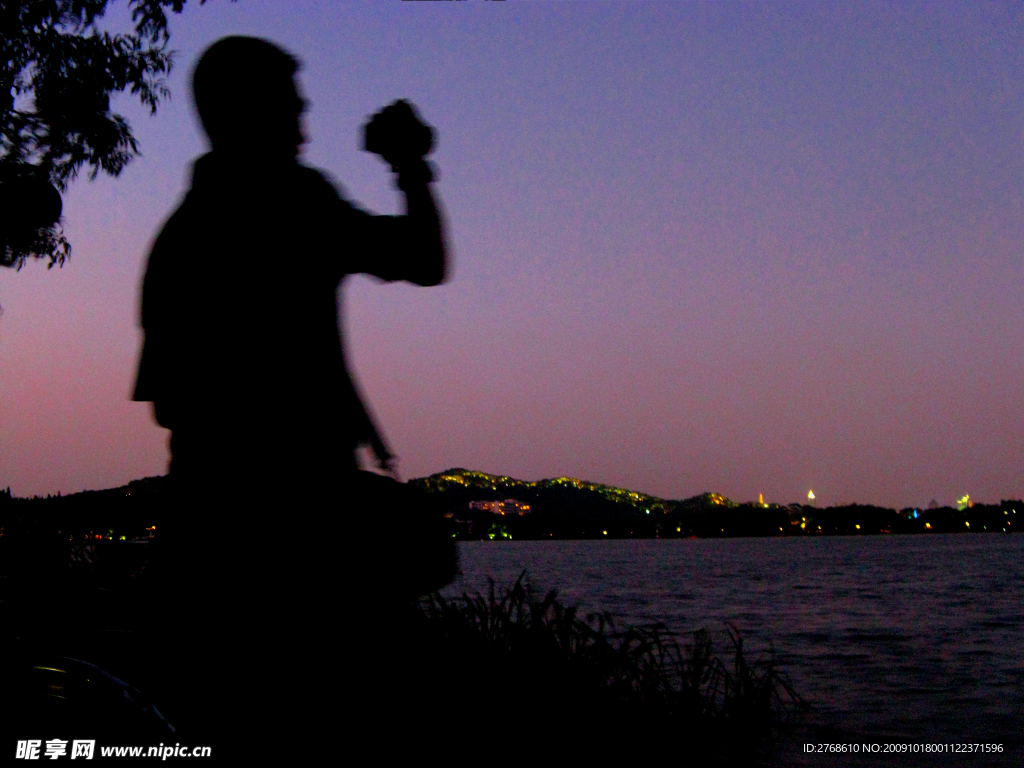 西湖边黄昏中的摄影者