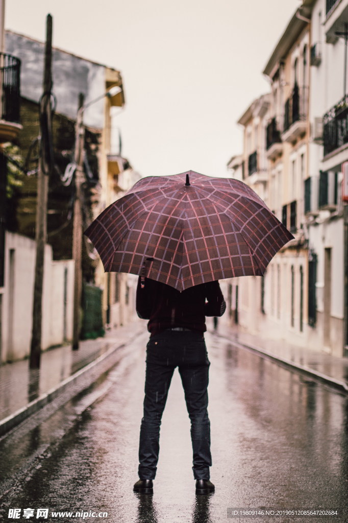 男人雨中撑伞背影图片