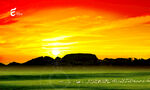 红色朝阳绿色草原远山羊群背景图