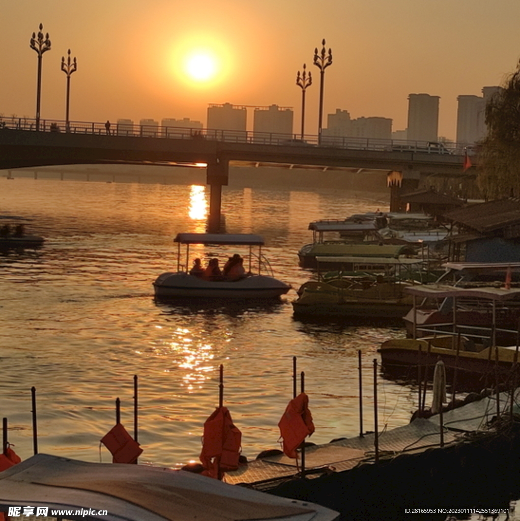 夕阳桥下小船阳光水面倒影波纹