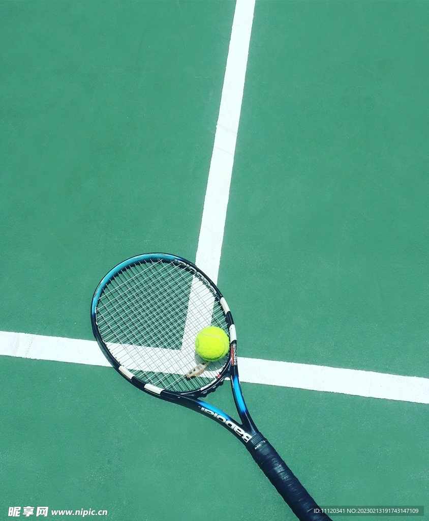 放在白色标线上的网球拍