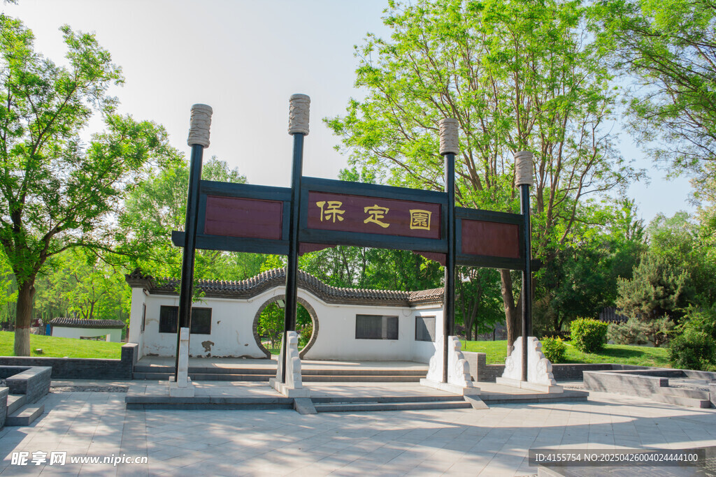 中式牌坊立于綠樹環(huán)繞處