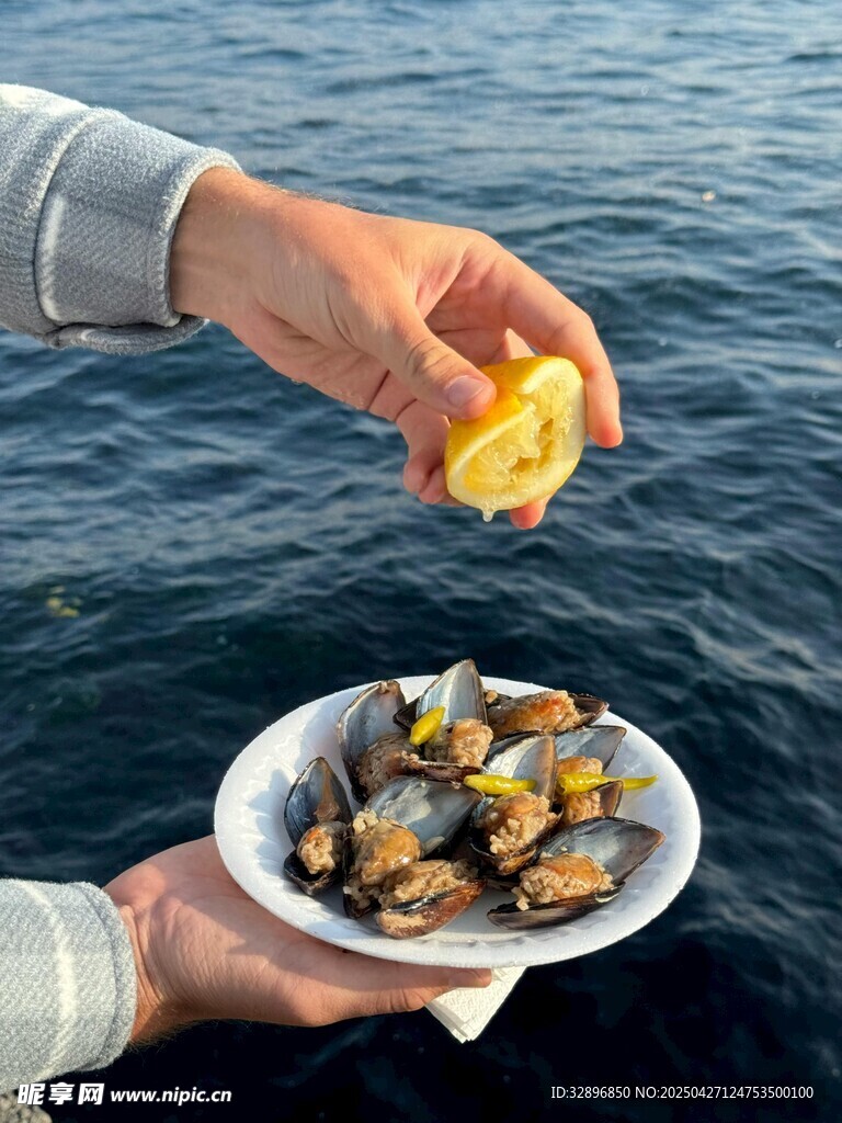 往盤中貽貝擠檸檬汁