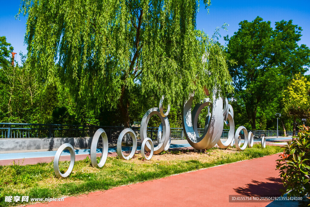 柳下環形雕塑的公園景致