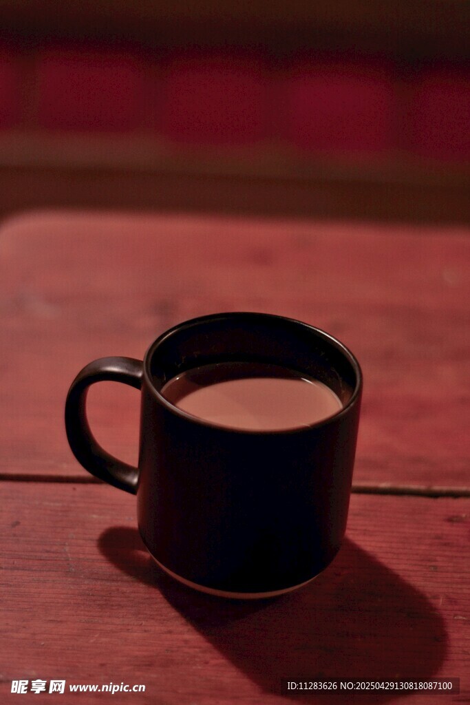 木桌上的黑色咖啡杯