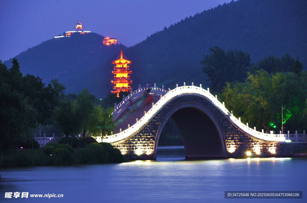 夜色中璀璨的拱橋與山巒