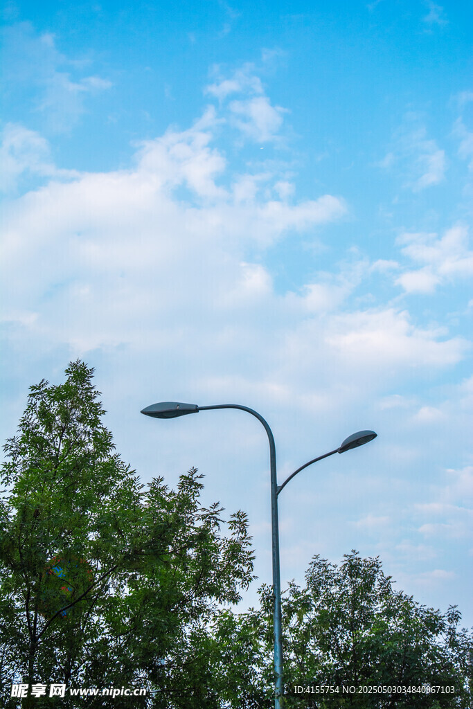 藍天綠樹間的路燈