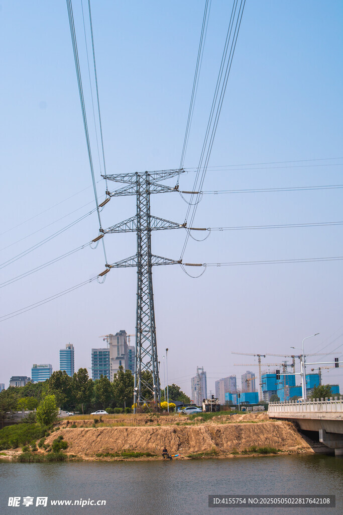 河畔輸電塔與城市遠景