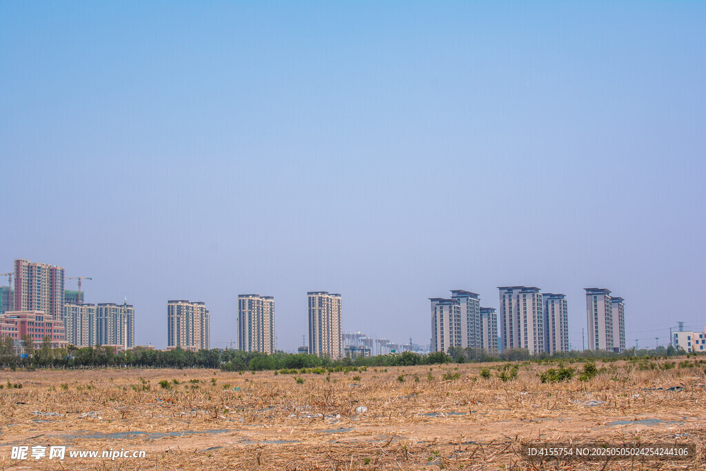 城郊荒地與遠處高樓景觀
