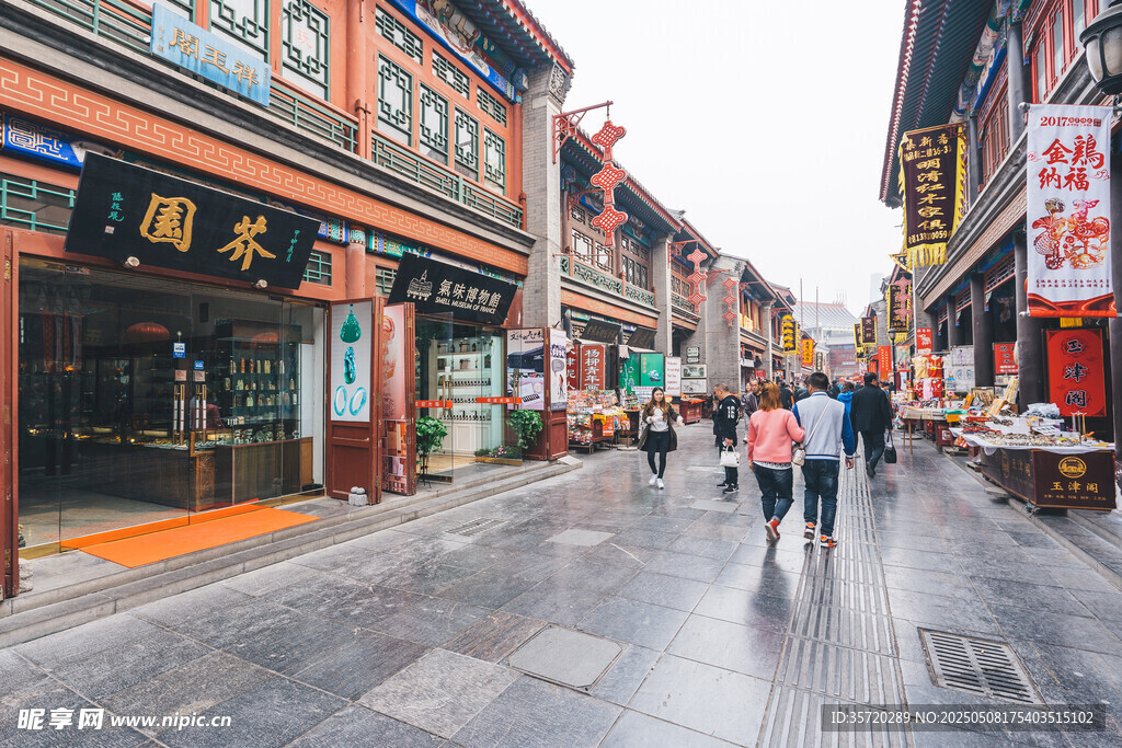 古街行人漫步雨中景象