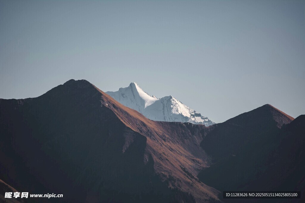 雪山映于山巒間壯麗景色