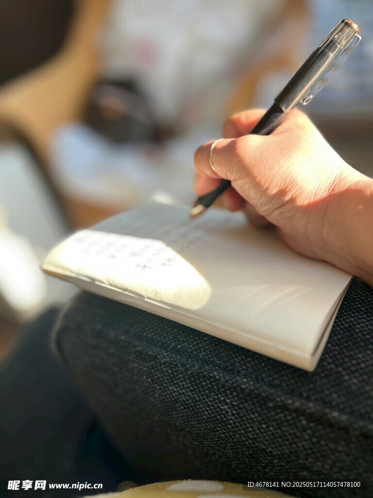 手執筆書寫于筆記本上