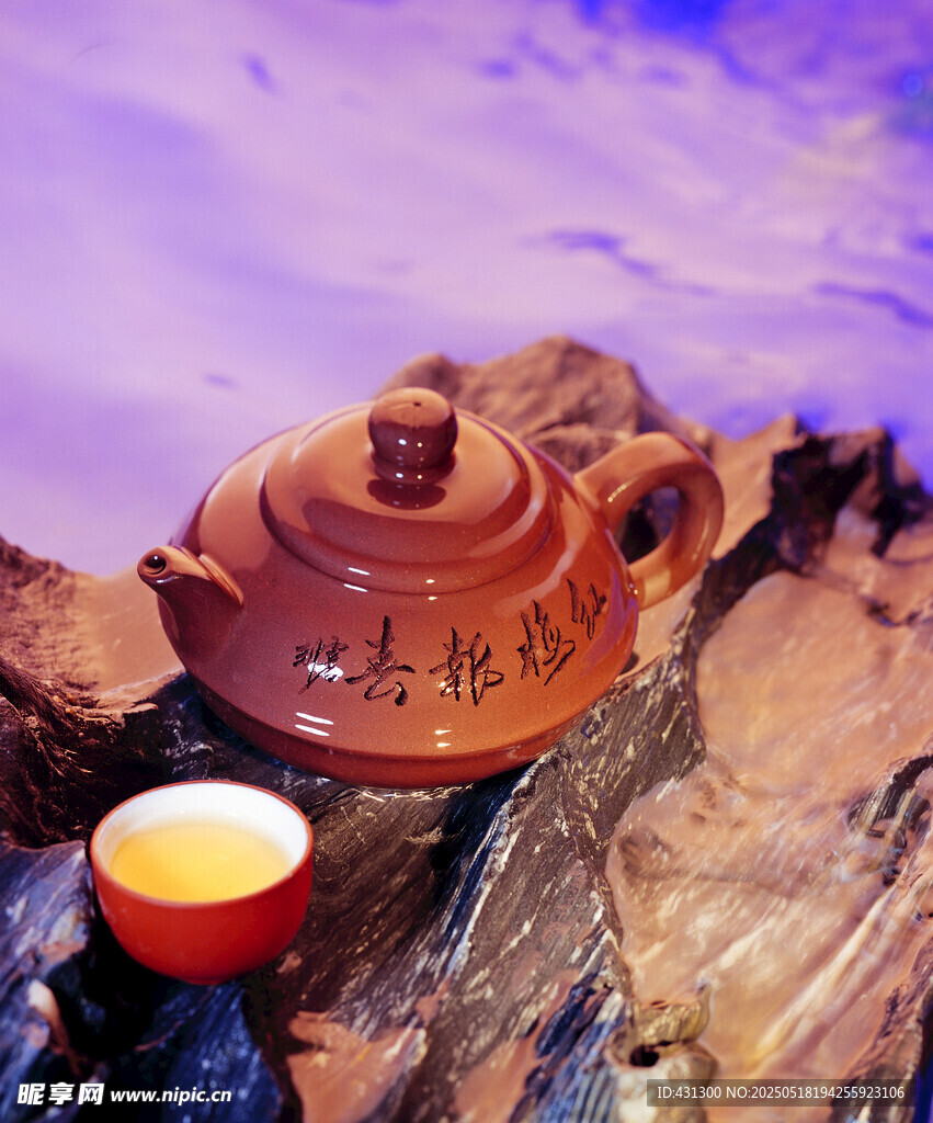 古樸茶壺與杯置于石上