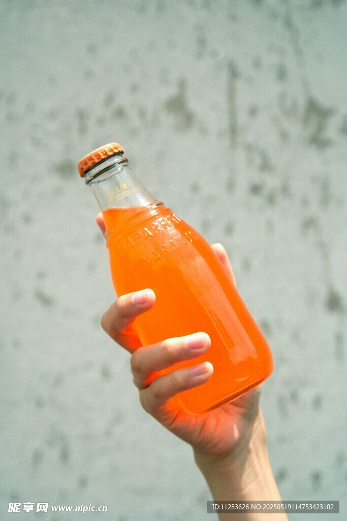 手捧橙色玻璃瓶飲料