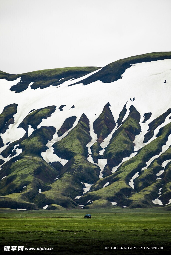 雪山下的翠綠山坡美景