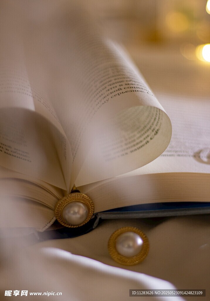翻開的書卷與珍珠裝飾