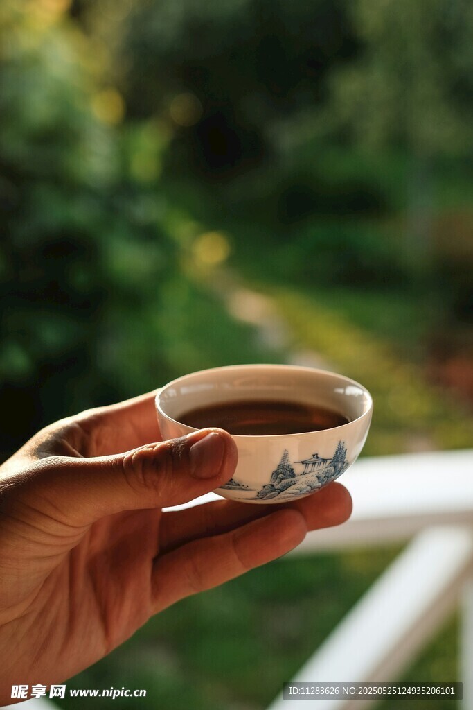 手持精致茶杯賞景