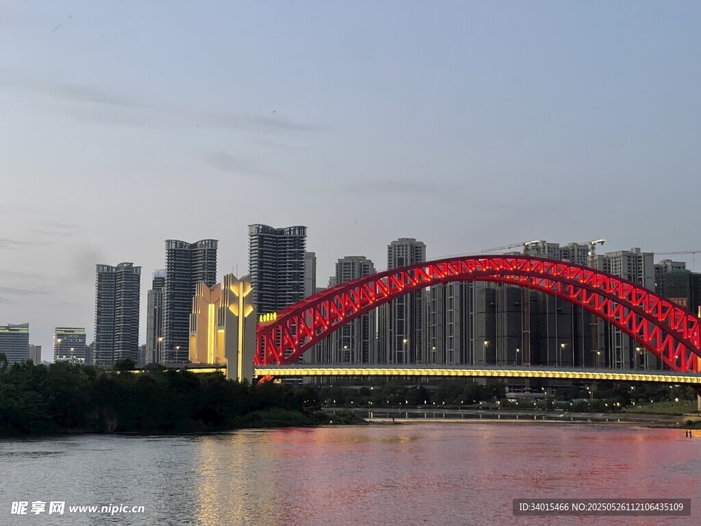 城市河畔的紅色拱形大橋