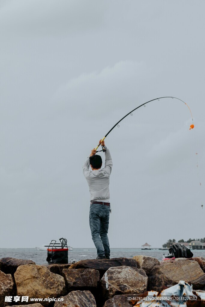 海邊垂釣者專注揮竿瞬間