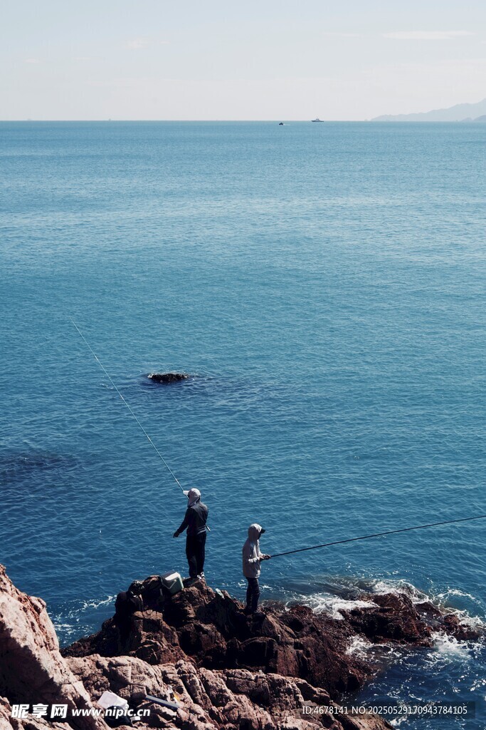 海邊巖石上的兩人觀景