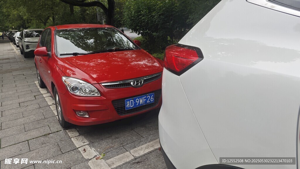 路邊停放的紅色與白色轎車