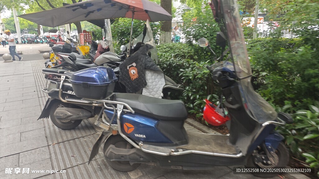 路邊停放的多輛電動摩托車
