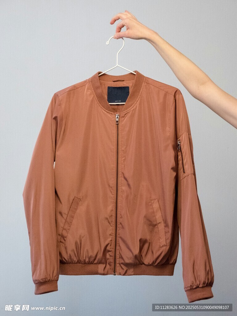棕色夾克被手懸掛展示