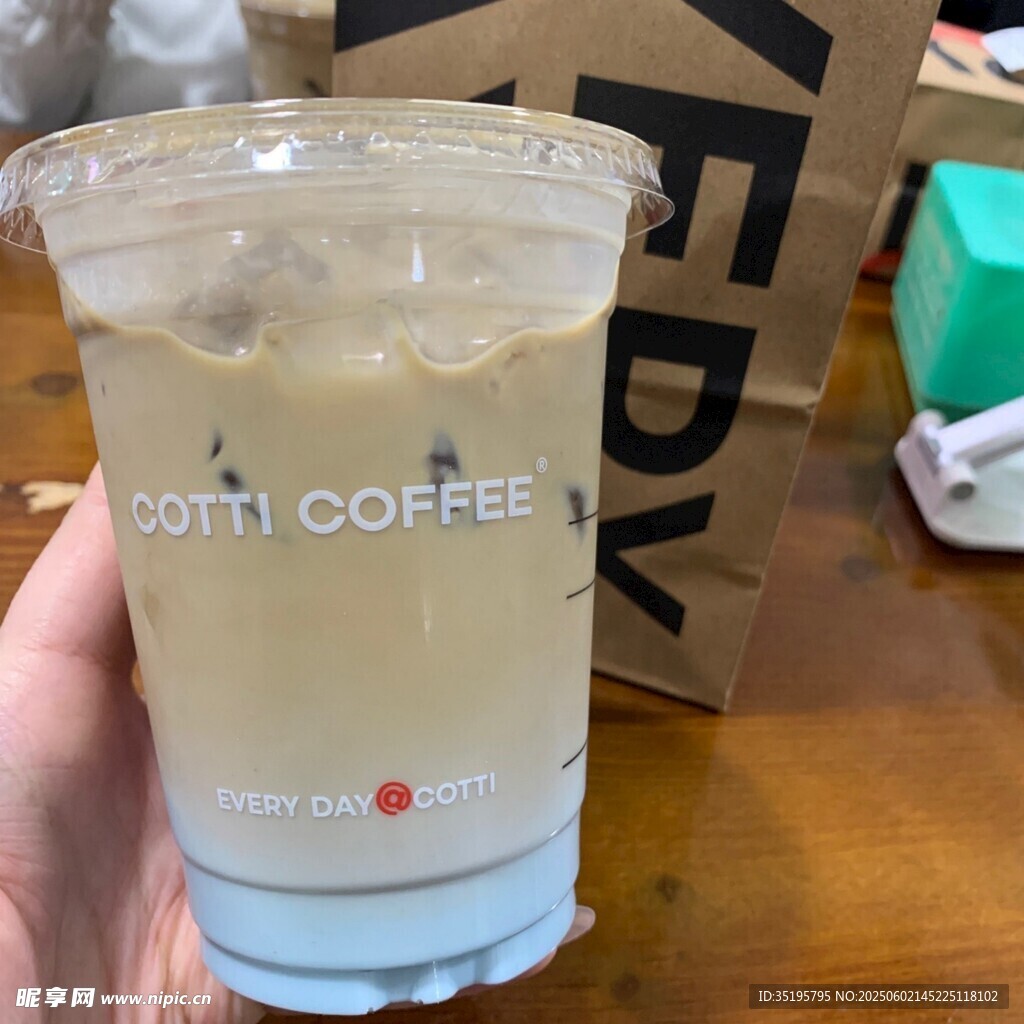手持一杯挪瓦咖啡飲品