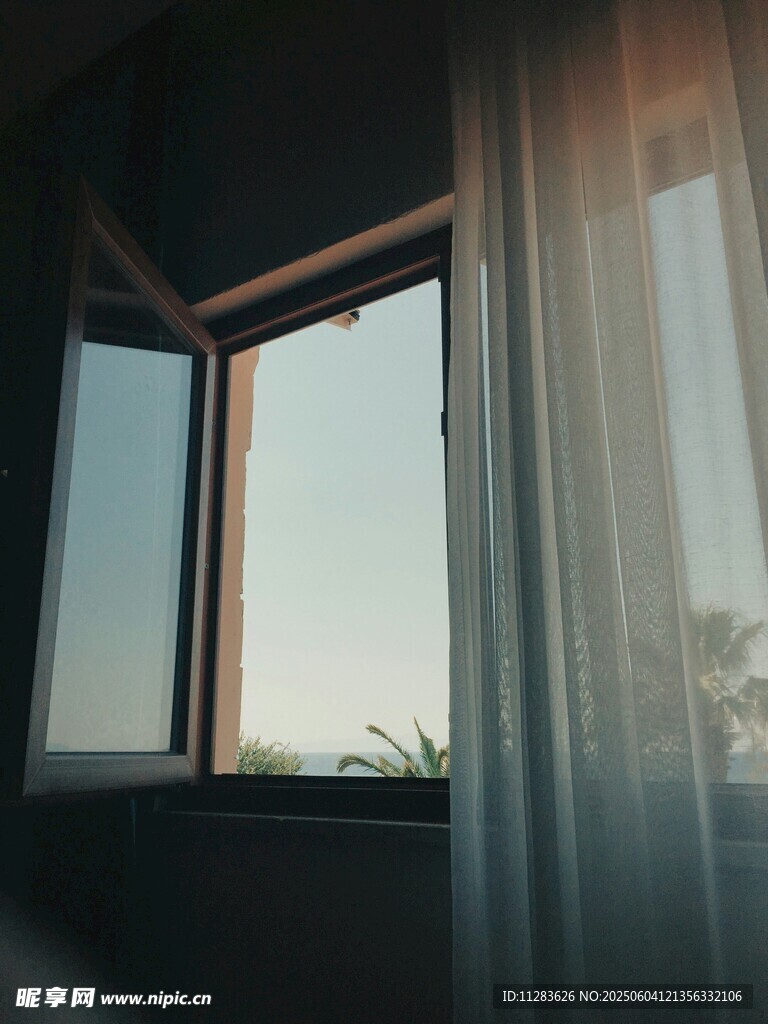 窗邊半掩窗簾望外風景