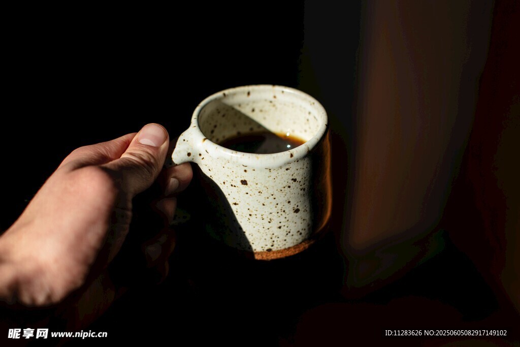 手持古樸陶瓷咖啡杯