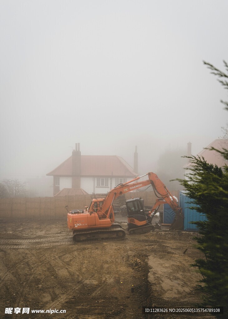 霧中施工的挖掘機與建筑