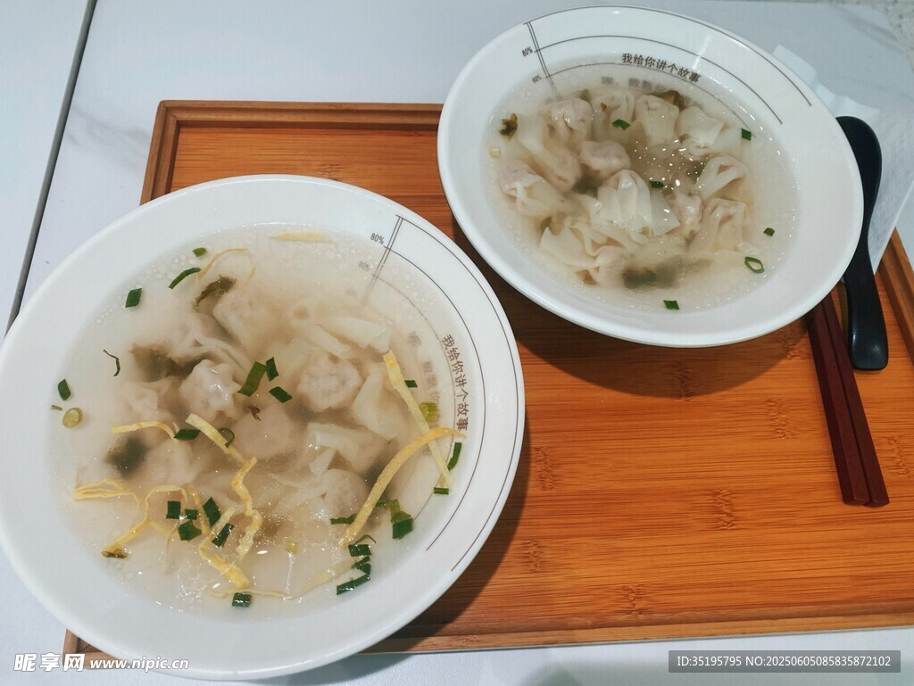 兩碗鮮香餛飩擺于木盤