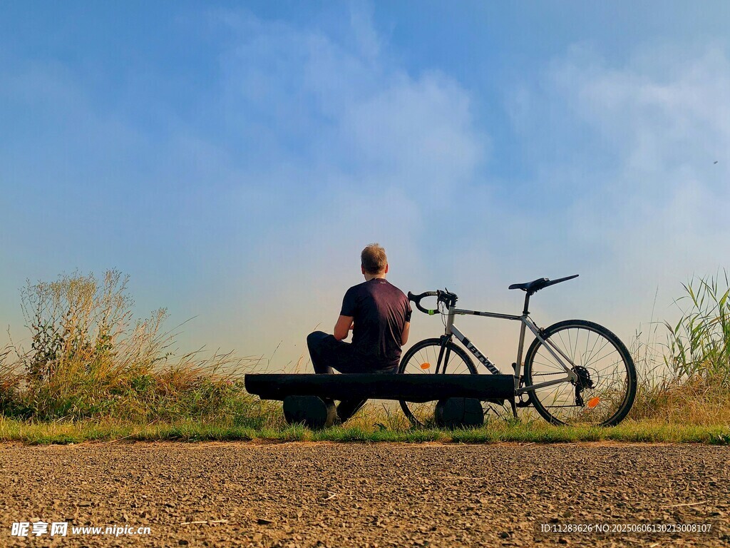男子休憩于自行車旁的美景