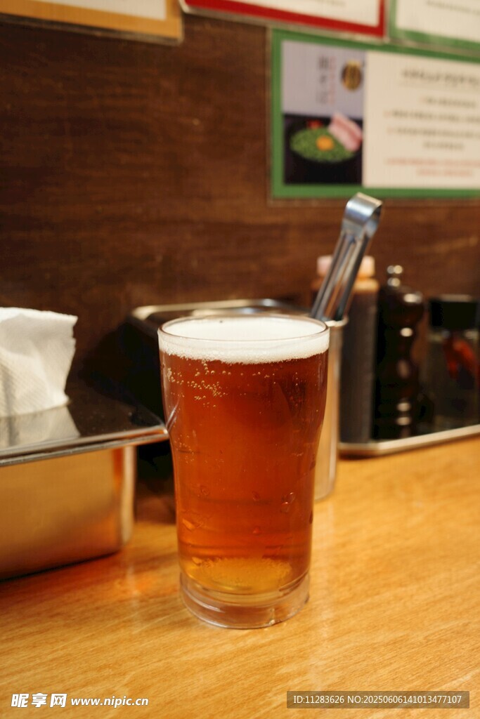 木桌上的一杯泡沫啤酒