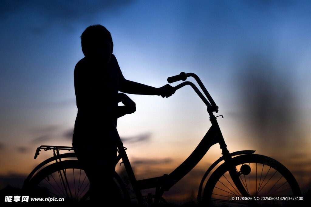 夕陽下騎車的女性剪影