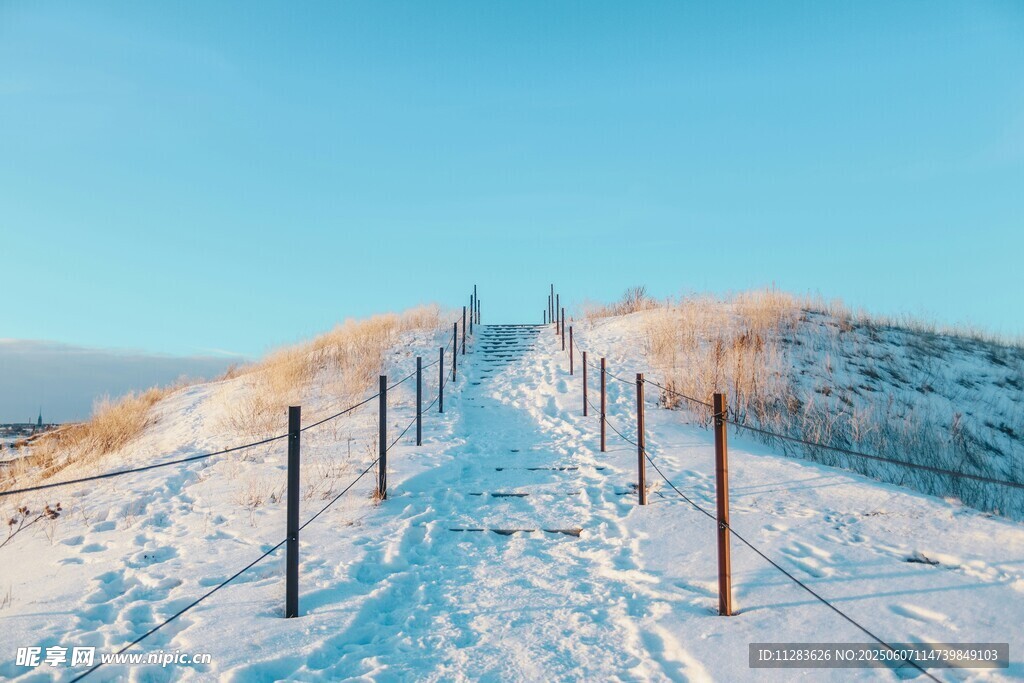 雪覆山坡的圍欄小徑