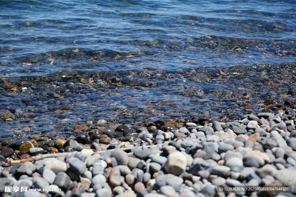 海邊鵝卵石與波光粼粼海水