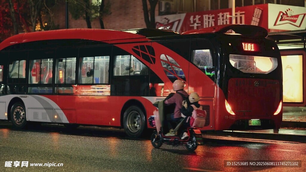 夜晚街邊的紅色大巴與行人