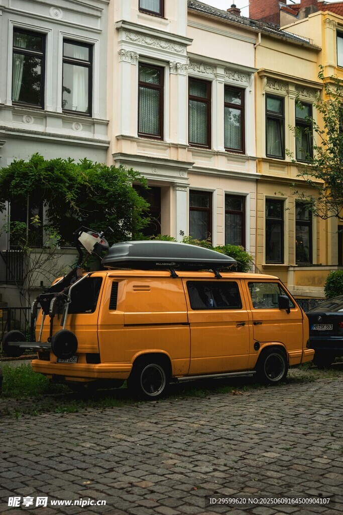復古橙面包車停于多彩建筑前
