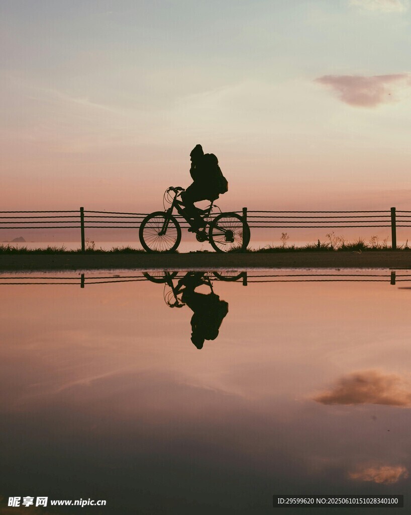 夕陽(yáng)下騎行者的水中倒影