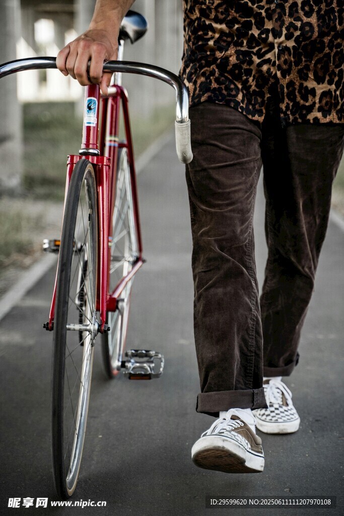 男子街頭推復古紅色自行車