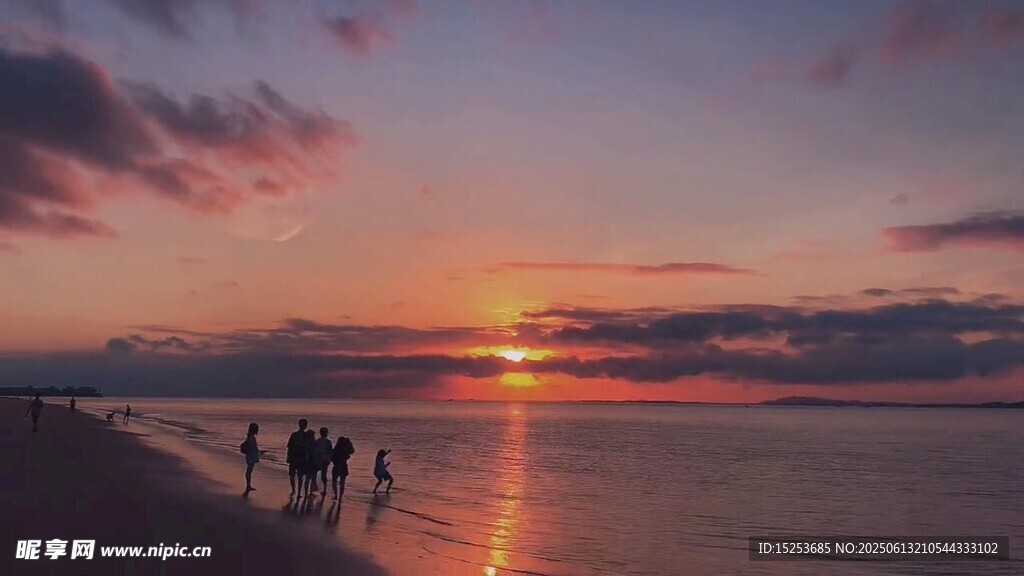 夕陽下漫步海灘的人群
