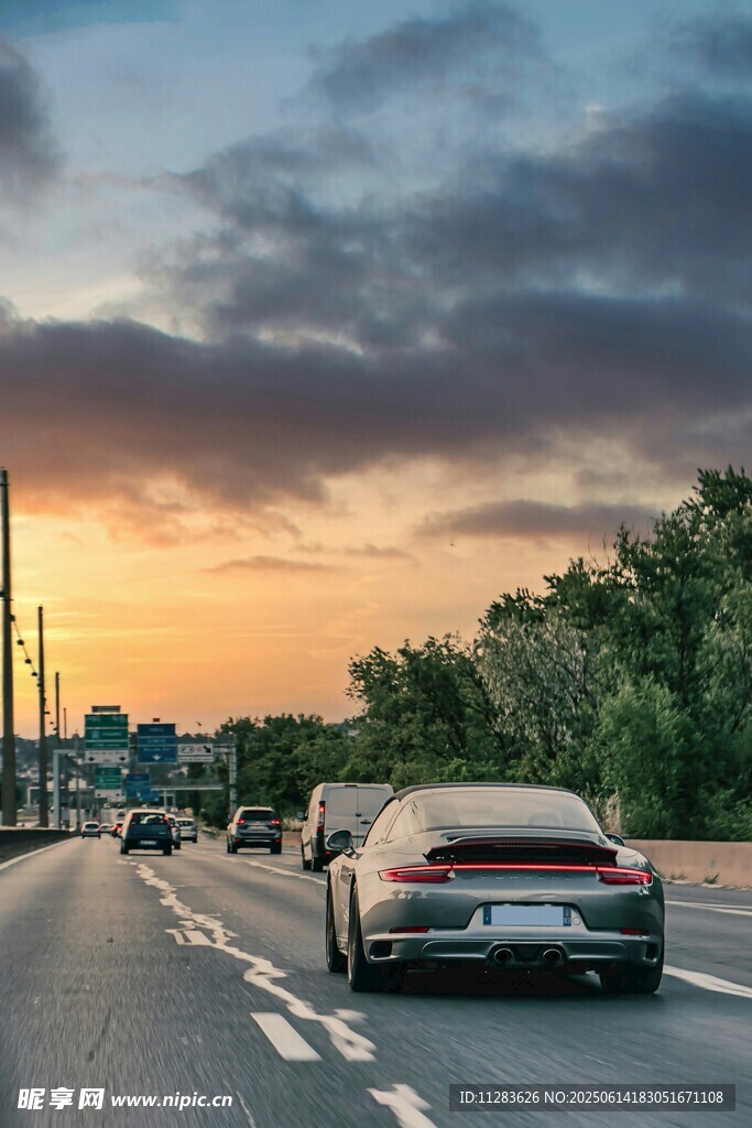 夕陽(yáng)下公路上行駛的汽車