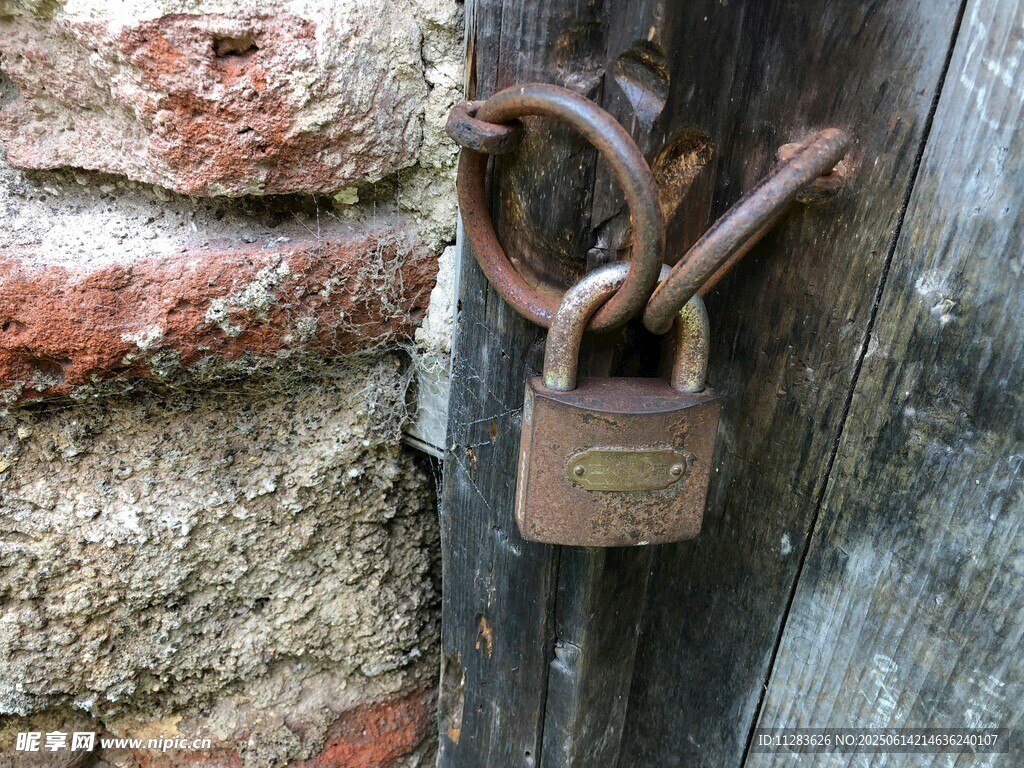 老舊鐵鎖掛于斑駁木門