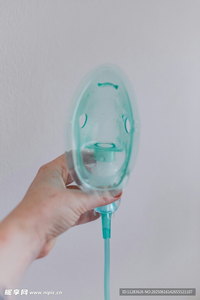 手持淺綠色醫(yī)療氧氣面罩