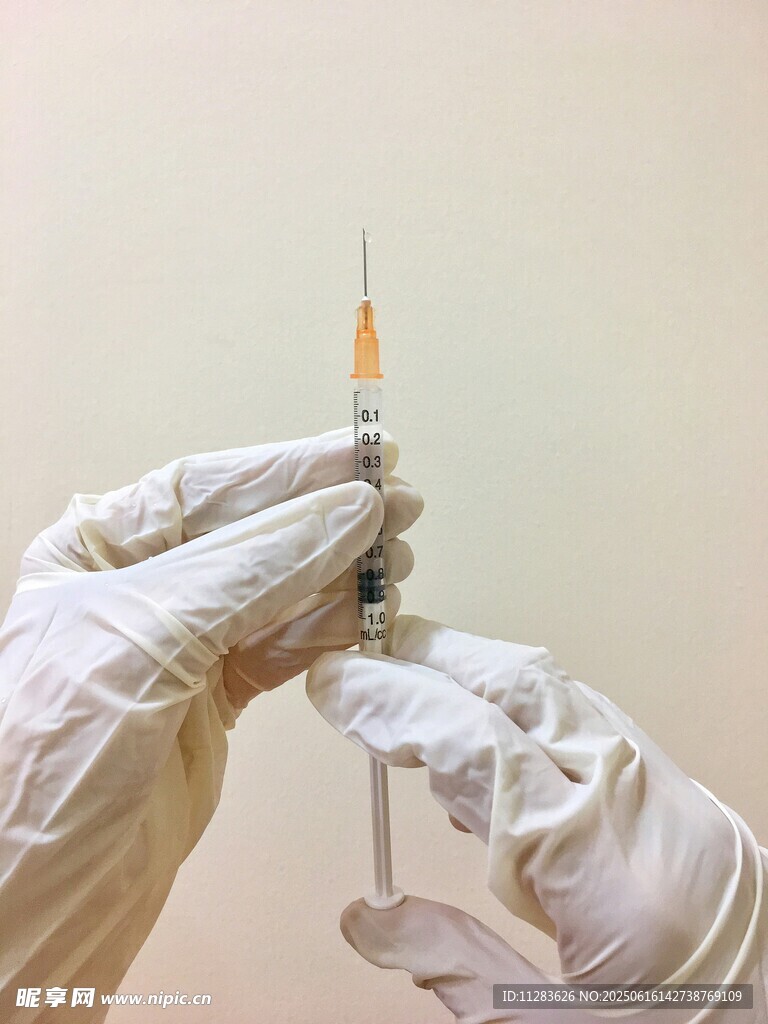 醫護人員手持注射器操作