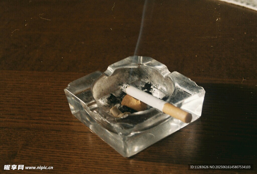 透明煙灰缸中燃著香煙