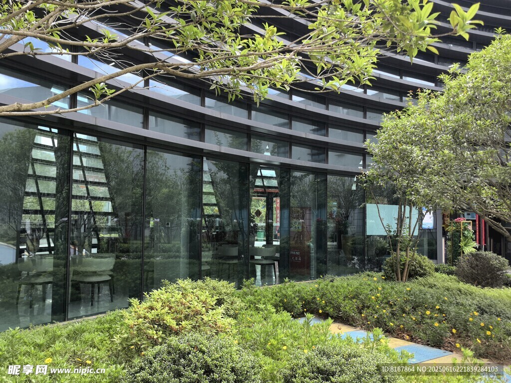 現(xiàn)代玻璃建筑旁的綠植景觀