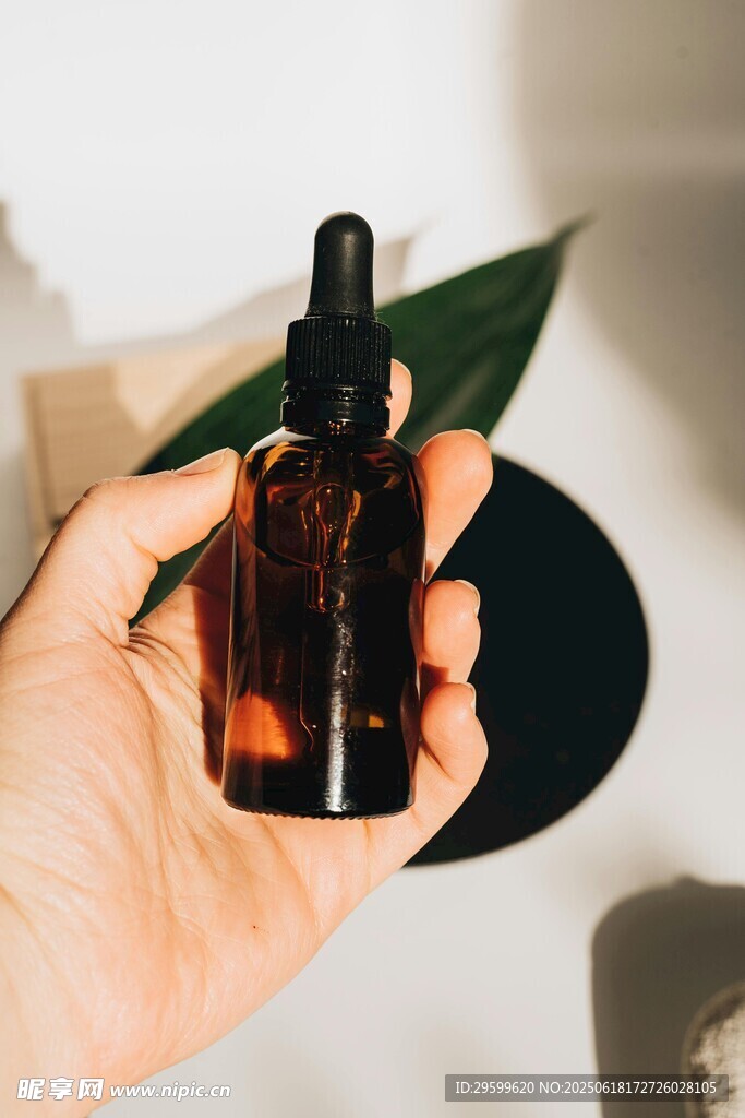手持棕色滴管瓶護膚品