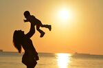 夕陽下母女海邊歡樂瞬間